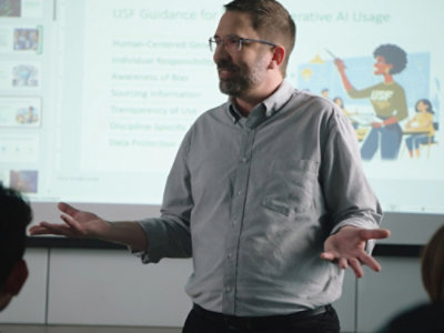 A person in a grey shirt giving a presentation