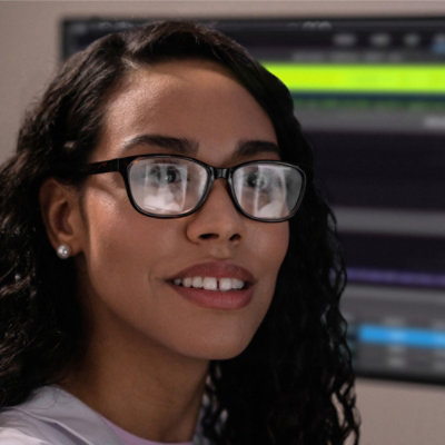 A woman wearing glasses and smiling.