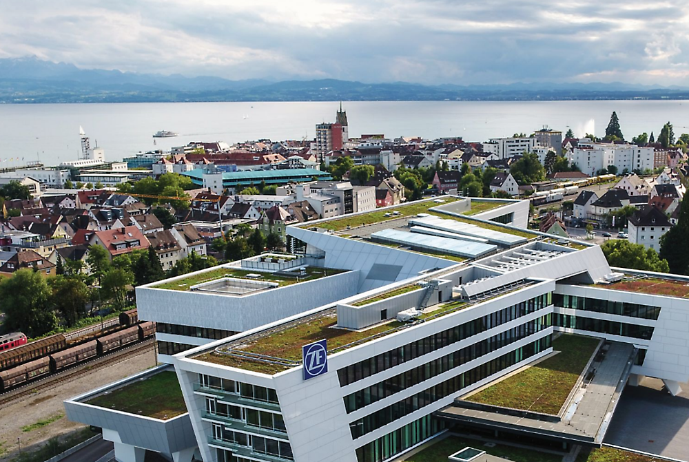 A large building with a green roof featuring the logo of ZF