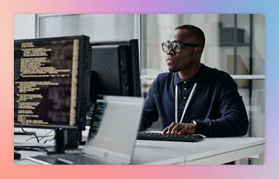 Persoon die aan een computer werkt met code op het scherm in een kantooromgeving.