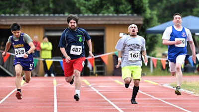 Four athletes running in the Special Olympics race.