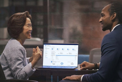 A man and woman looking at a laptop.