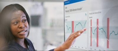 A person pointing at a graph on a computer screen.