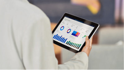 一个人拿着一台平板电脑，电脑上显示 Azure 中图表和关系图