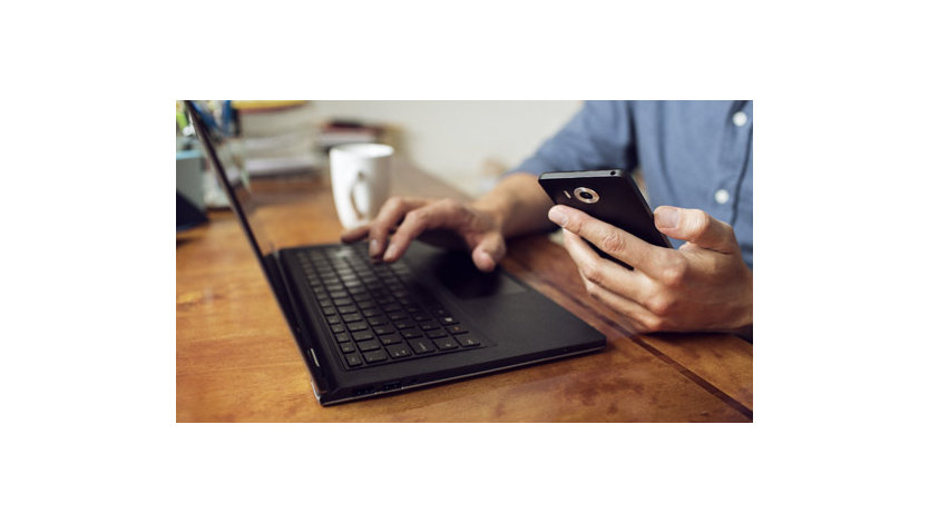 Hände mit Tastatur und Smartphone