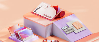 すっきり整理された本やアイテムのディスプレイ。"増幅" と書かれたボックスや、," カラフルな数枚のカードが含まれています。