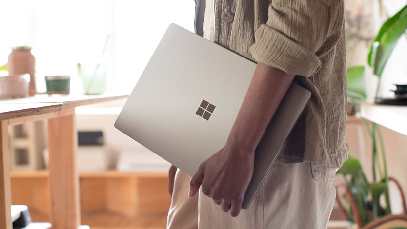 A person carries a refurbished Surface device.