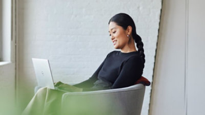 A person sitting in a chair using a laptop.