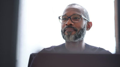 A person looking at a desktop monitor.