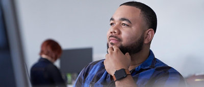 A man touching his cheek and looking somewhere.