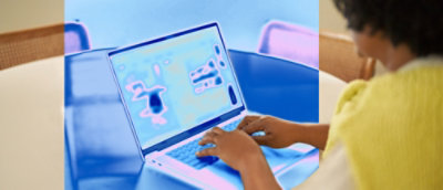 Een close-up van handen die op een laptop typen.