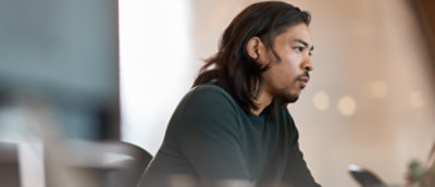 Homme avec des cheveux longs assis dans une pièce.