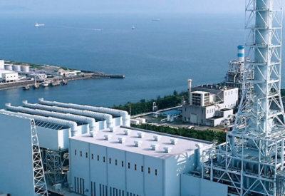 A large factory next to the ocean.