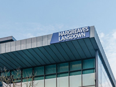 Building exterior with the sign "Hargreaves Lansdown" on the roof against a clear sky.