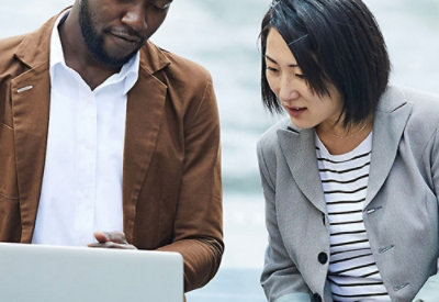 A man and woman looking at a laptop.