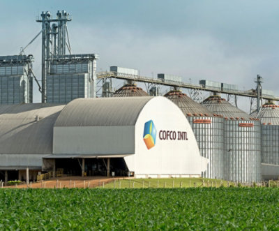 具有標誌 COFCO INTL PE 的大型白色建築物，背景為綠色田野。