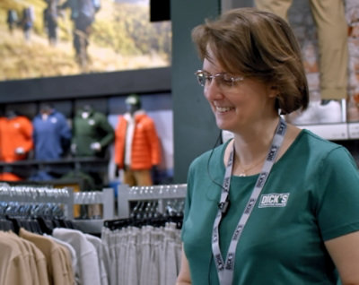 A woman wearing a green shirt in a clothing store.