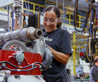 Nainen hymyilee ja pitelee konetta.