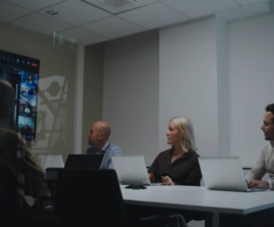 一男一女坐在桌前，桌上有膝上型電腦。