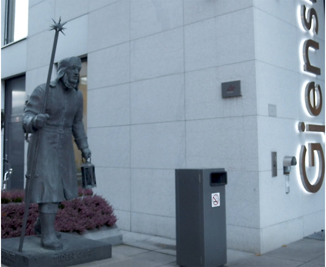 建物の前に立っている男性の像。