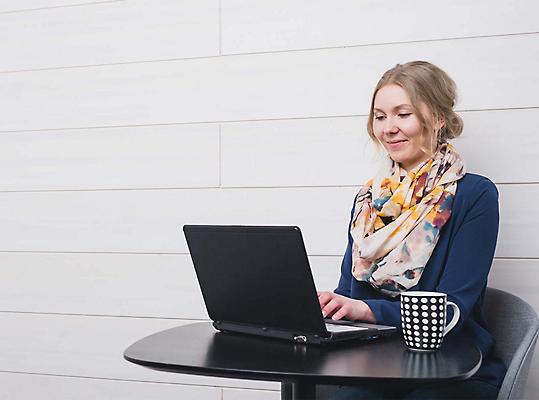 A person sitting at a table using a laptop