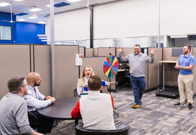 Una persona in piedi davanti a una ruota della fortuna