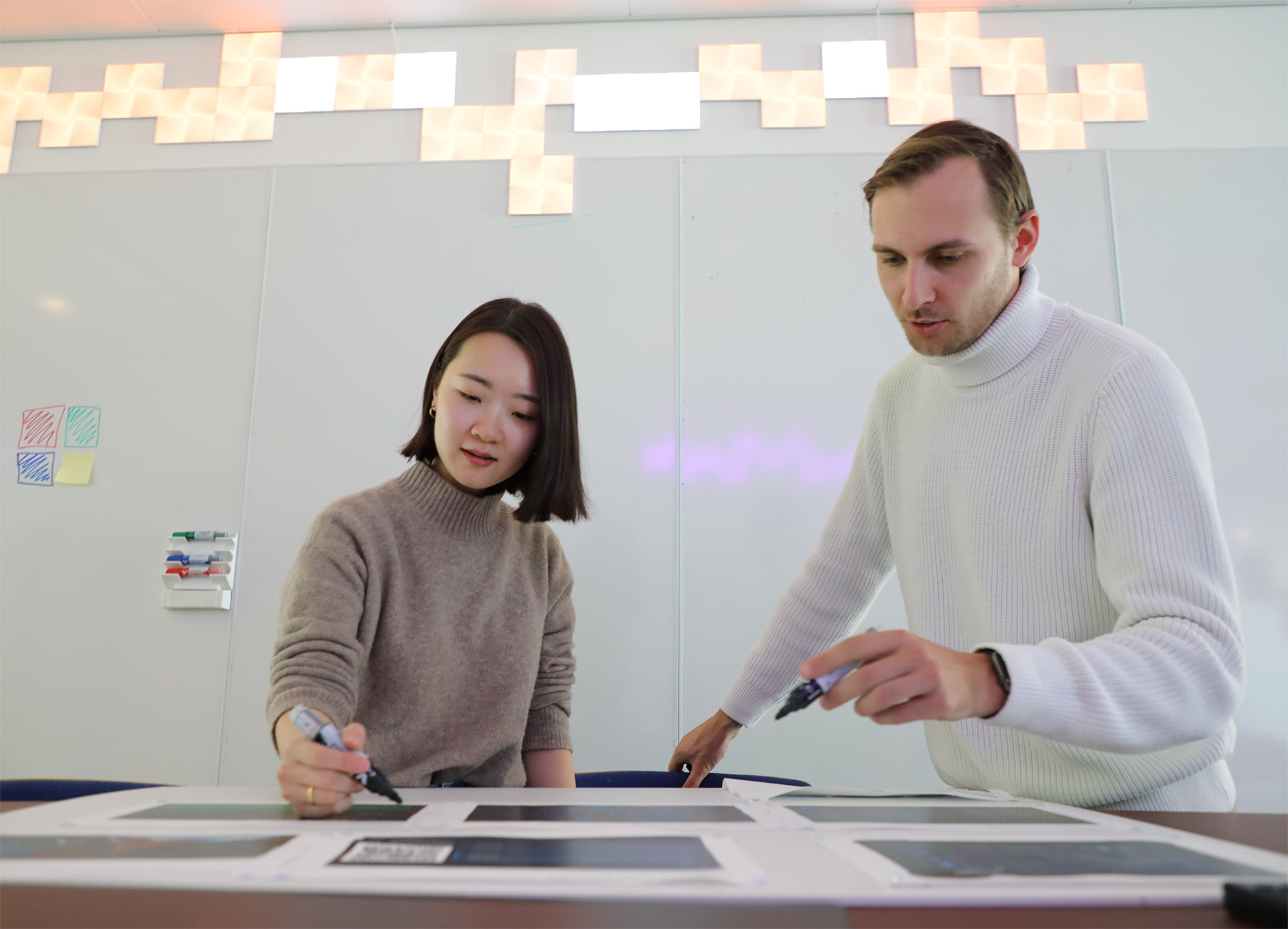2 persons discussing with marker in their hand
