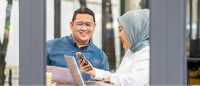 A man and woman looking at a phone.