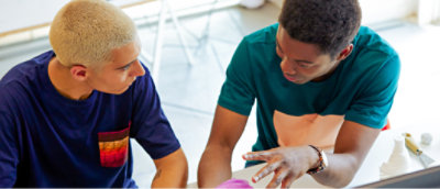 A couple of men smiling and giving thumbs up.