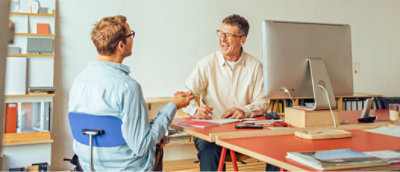 a man and woman sitting at a desk.