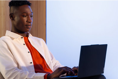 A man in a white jacket using a laptop.