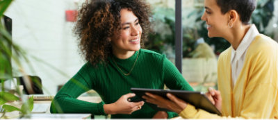 Two girl in a green & yellow shirt holding a tablet