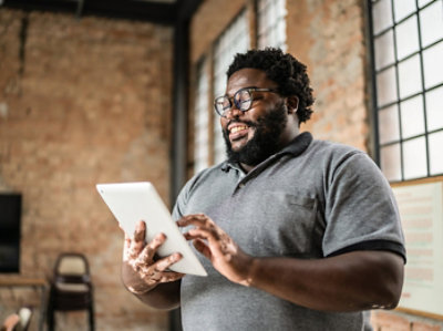ひげを生やし、眼鏡をかけ、タブレットを持っている男性。