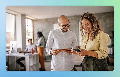 A man and woman looking at a tablet.