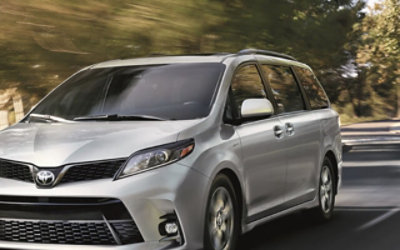 Mobil minivan Toyota berkeliling di jalan perumahan