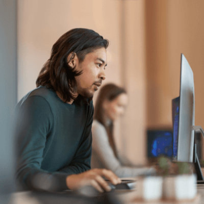 椅子に座ってデスクトップで作業している人