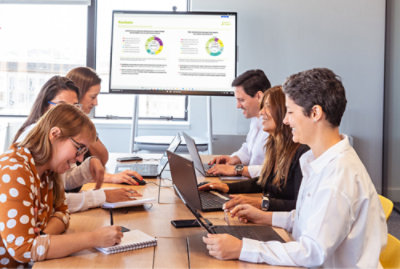 노트북을 가지고 테이블에 앉아 있는 한 무리의 사람들.