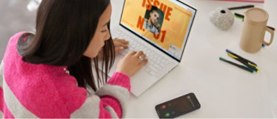 ピンクと灰色のセーターを着た人が、画面に「問題番号 01」と表示されたノート PCを使用している。