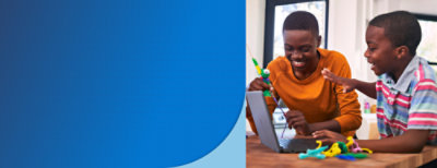 Dois meninos brincando com um laptop na frente.