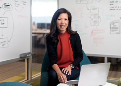 테이블에 앉아 노트북을 사용하는 한 여성.