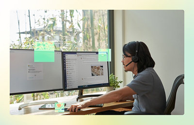 A person wearing headphones and sitting at a desk using a computer.