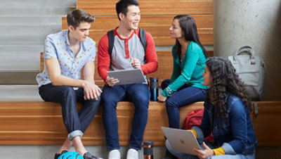 Four students working together with Surface Pro 7 and Surface Book 2 devices