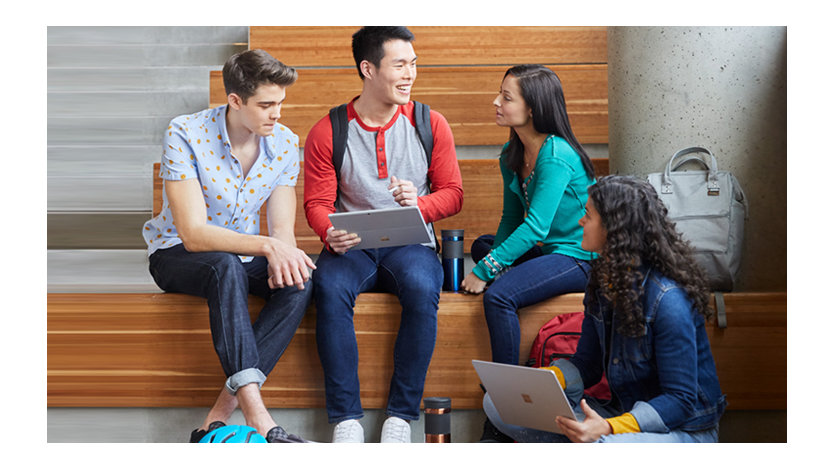 Four students working together with Surface Pro 7 and Surface Book 2 devices