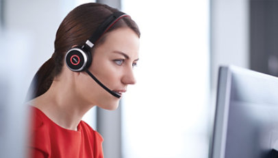 A woman wears Jabra Evolve 65 while on a call at her computer.