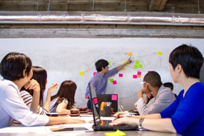A team member leading a workstream session on a whiteboard.