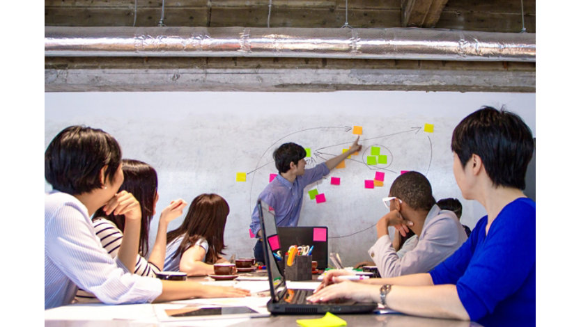 A team member leading a workstream session on a whiteboard.