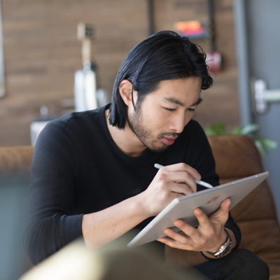 A man with black hair working on tablet