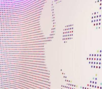 Abstract digital pattern with a gradient of multicolored dots on a white background.