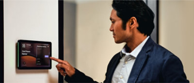 A man in a blue blazer touching a device