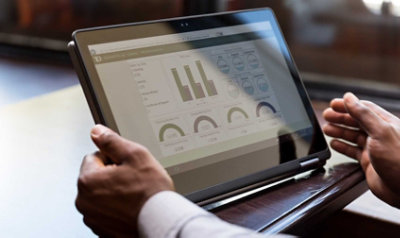 Two hands holding a tablet displaying data in the TD app